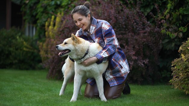 A menina brinca e abraça seu amado cachorro akita inu