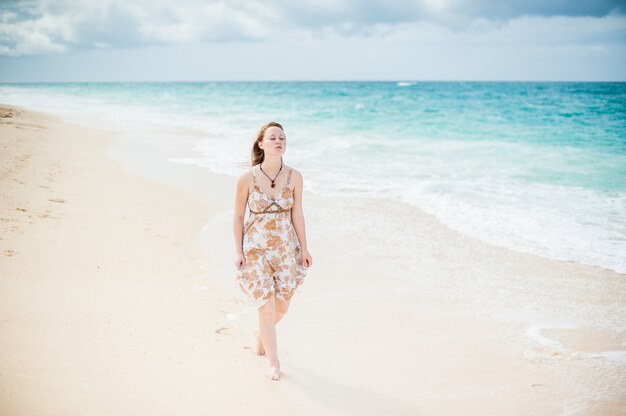 A menina caminha à beira da água no boracay