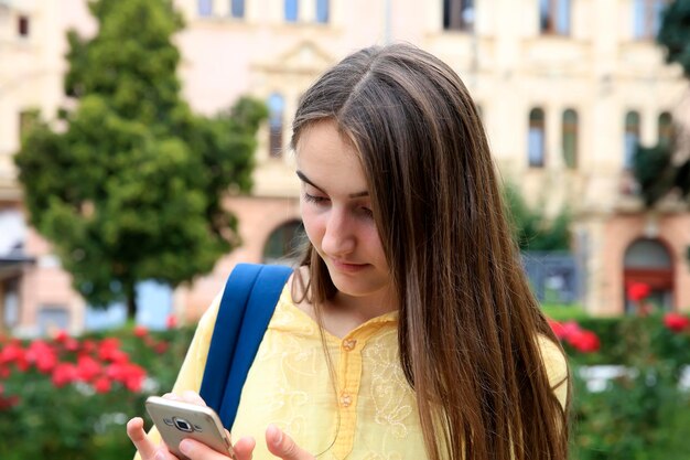 A menina com um telefone celular lê uma mensagem