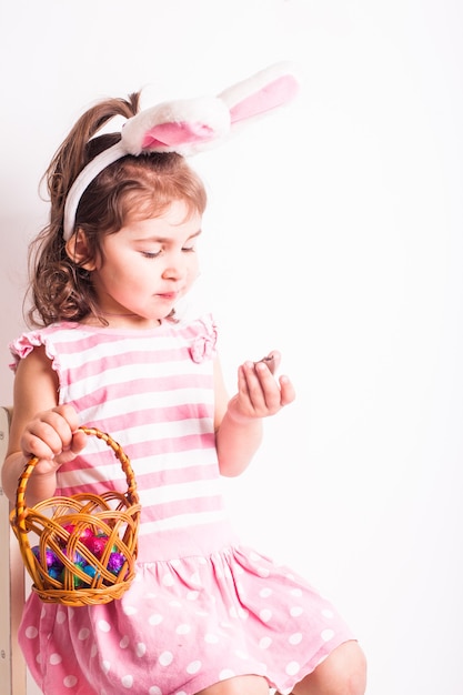 Foto a menina come uns ovos de chocolate depois da caça à páscoa