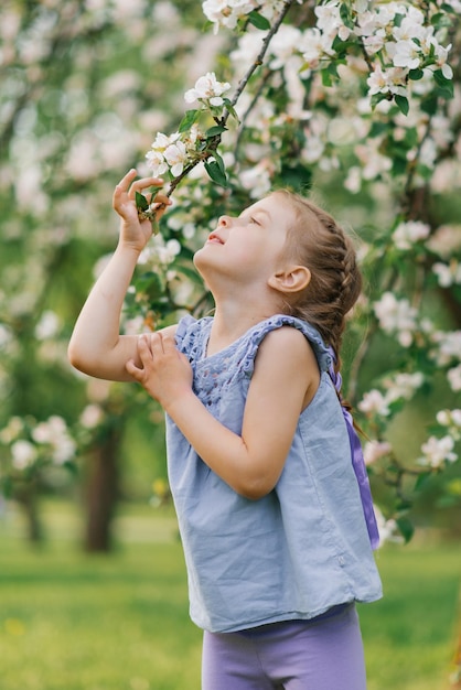 A menina da criança está brincando no parque na primavera