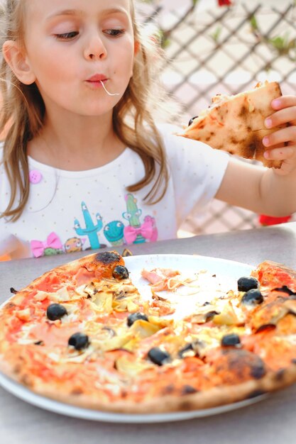 A menina da criança está comendo pizza