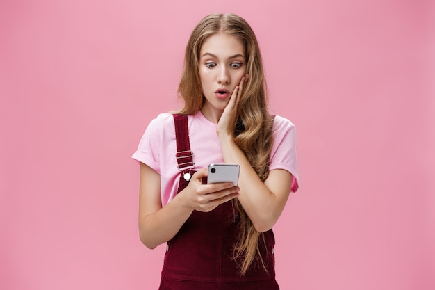 A menina descobriu uma verdade chocante depois de ler a mensagem no smartphone, pressionando o braço na bochecha em surpresa ...