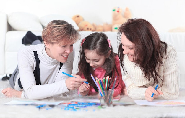 A menina desenha com sua mãe e avó