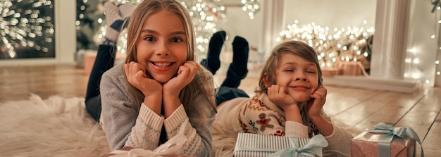 Foto a menina e o menino felizes com presentes no chão