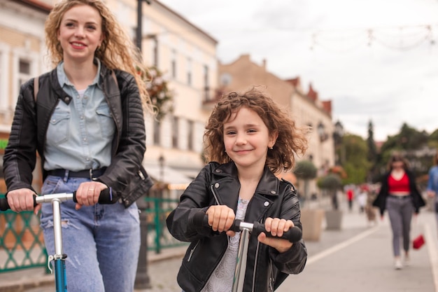 A menina elegante anda de scooter na cidade