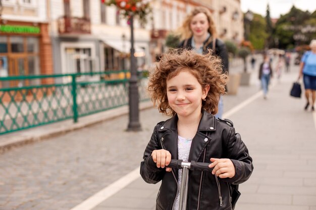 A menina elegante anda de scooter na cidade