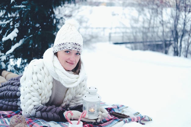 A menina encontra-se na neve na floresta de inverno ou parque conceito natal férias e feriados