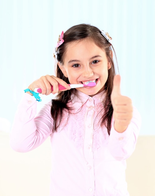 A menina escovando os dentes.