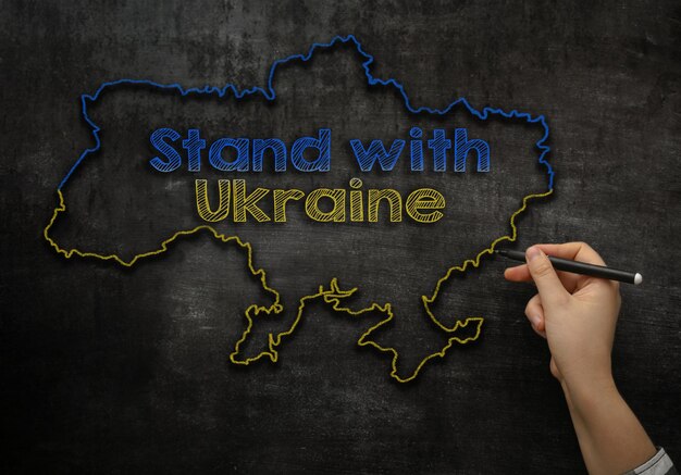 A menina escreve no quadro preto o texto com a ucrânia
