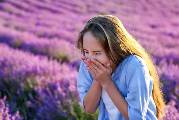 A menina espirra alérgica a flores de lavanda