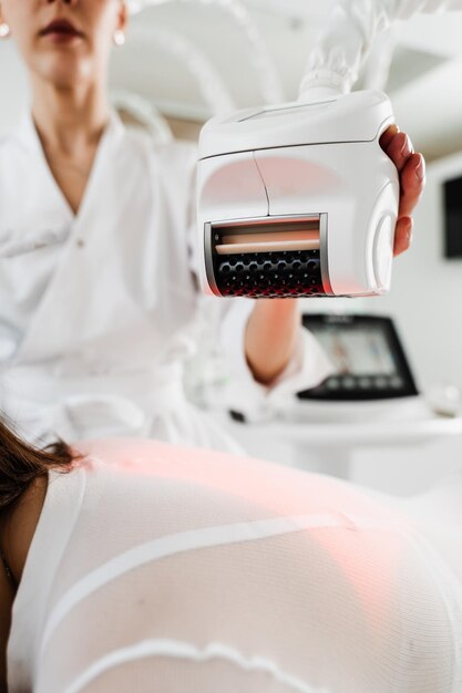 A menina está a fazer uma massagem de drenagem linfática nas pernas para aliviar o inchaço dos tecidos, lidando com as células gordurosas, curando o linfedema com massagem guiada por máquina.