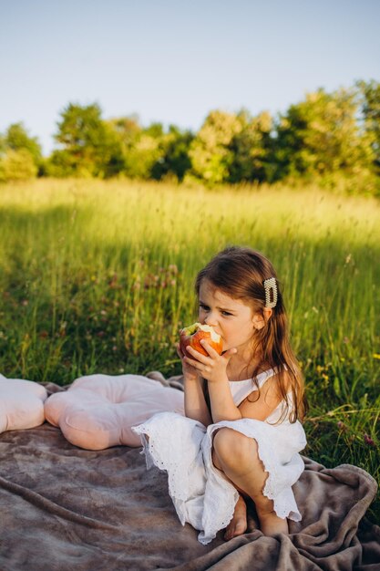 A menina está comendo uma maçã