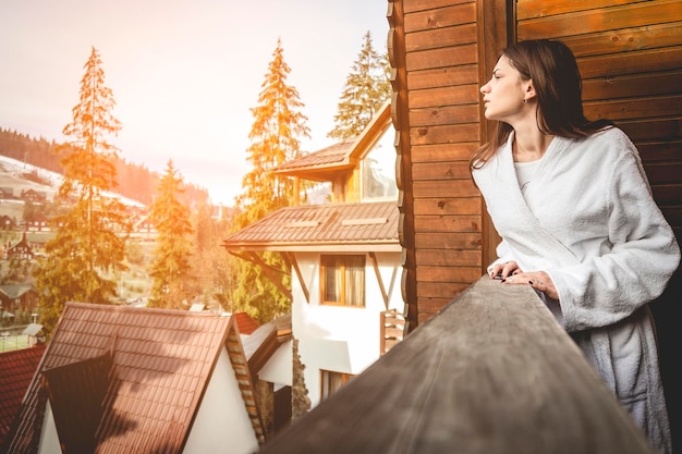 A menina está em uma casa geminada em uma área montanhosa com bom tempo de inverno