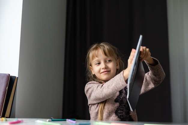 A menina está fazendo sua lição de casa para a escola primária.