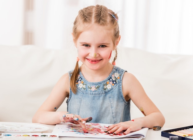 A menina está feliz em desenhar em seu tempo livre