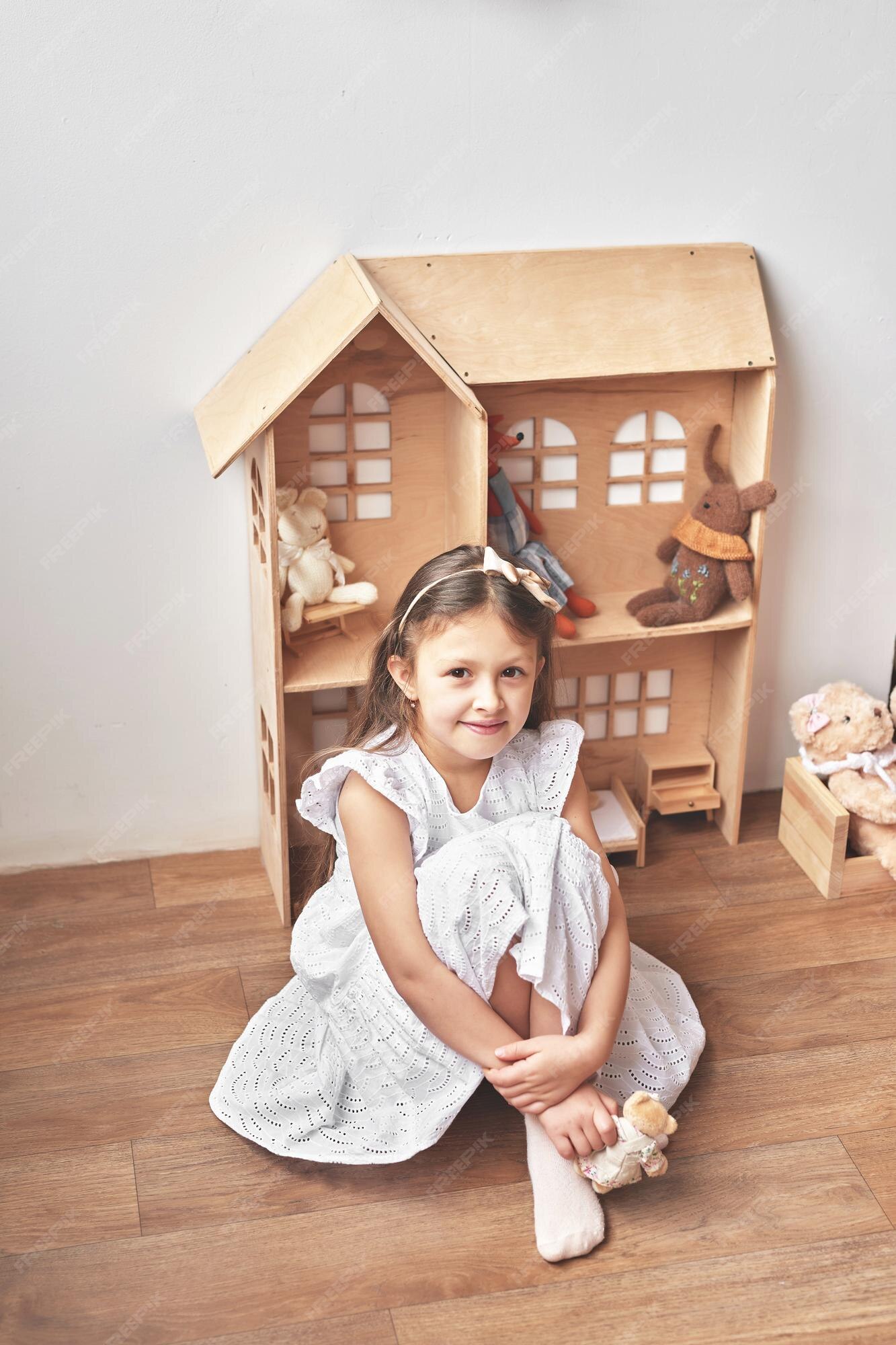 A menina está jogando na sala de jogos infantil berçário escandinavo  brinquedos de madeira e decoração