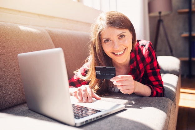 A menina está pronta para pagar com cartão de crédito em uma loja online