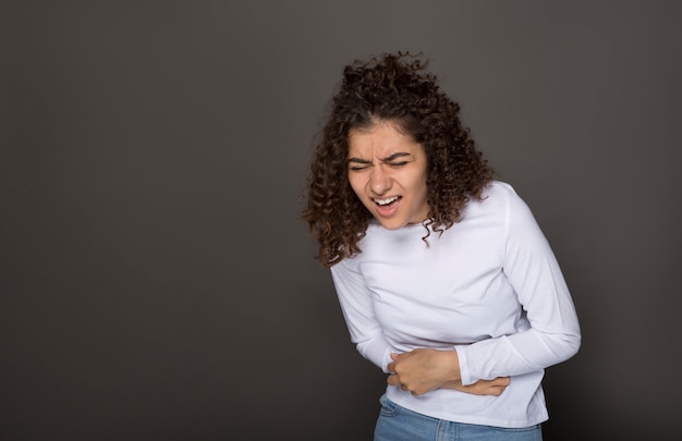 A menina está segurando o estômago. Dor abdominal. Diarréia.