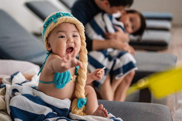 A menina está tentando pegar o brinquedo que os pais dela deram na frente do pai e do filho.