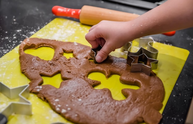 A menina faz biscoitos de gengibre para o natal sozinha