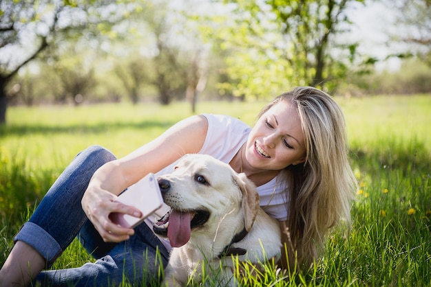 A menina faz selfie com um labrador