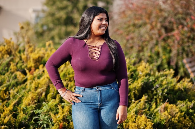 A menina modelo latino xxl bonita do equador veste a blusa violeta posada na rua.