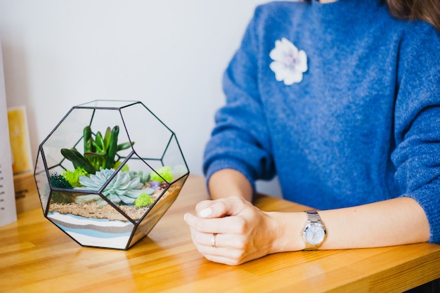 A menina planta uma forma de vidro, plantando flores, vidro terarium