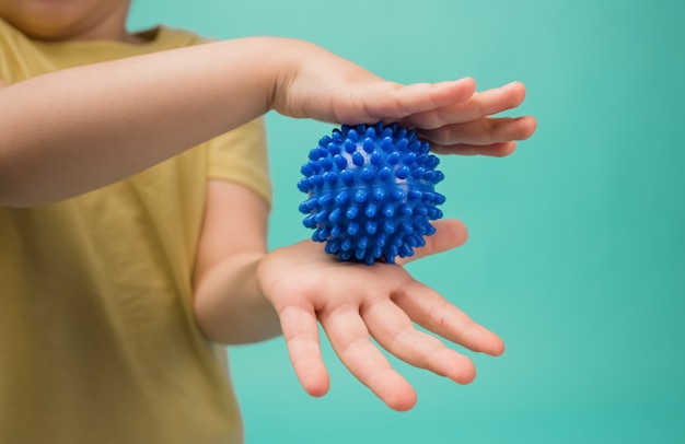 A menina prende a bola azul dos esportes em suas mãos