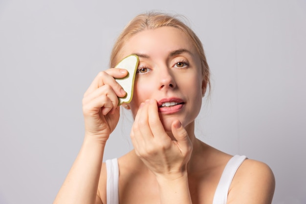 A menina realiza escova de massagem com guache e massagens a vácuo para levantamento e rejuvenescimento da pele facial