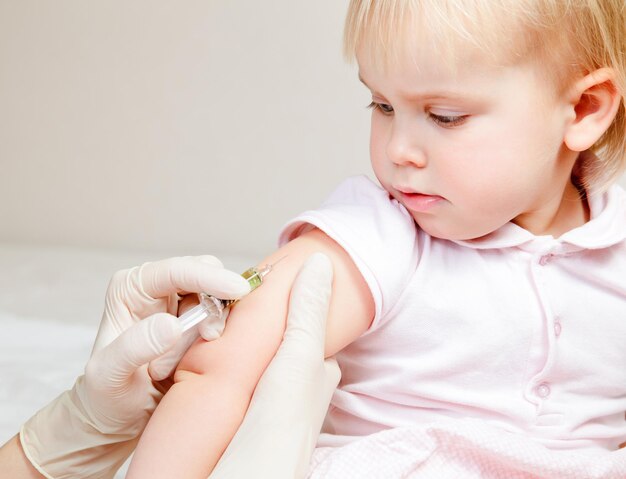 A menina recebe uma injecção.