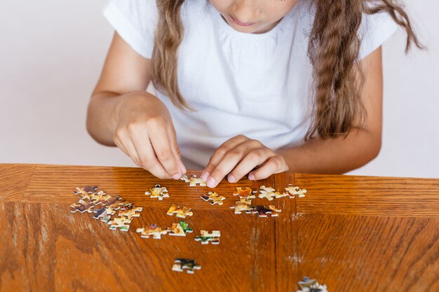 A menina recolhe peças para fazer uma imagem, quebra-cabeças, desenvolvimento da mente, habilidades, compreensão, brincar, passar um tempo, se comunicar com os pais, mãe