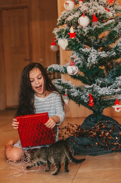 A menina se surpreende ao abrir presentes de natal