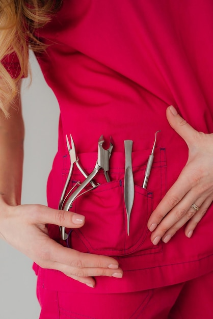 Foto a menina segura ferramentas de manicure em seu bolso estilo clippers de unhas empurrador