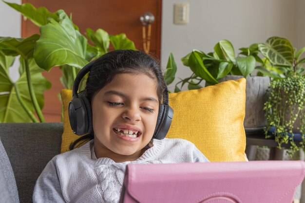 A menina sentada está brincando com seu tablet