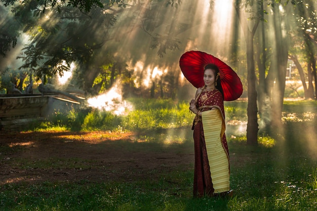 A menina tailandesa das mulheres bonitas que guarda a mão A festão do jasmim no traje tailandês tradicional com ayutthaya do templo é ouro da textura, cultura da identidade de Tailândia.