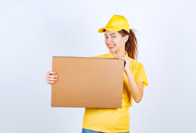 A mensageira de uniforme amarelo entregou um pacote de papelão no endereço correto.