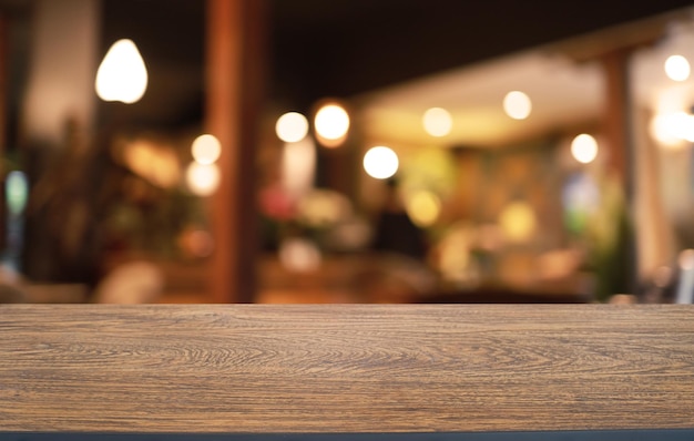 A mesa de madeira vazia na frente do fundo desfocado abstrato da cafeteria pode ser usada para exibição ou montagem de seus produtos Mock up para exibição do produto