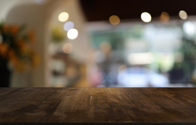 A mesa de madeira vazia na frente do fundo desfocado abstrato da cafeteria pode ser usada para exibição ou montagem de seus produtos Mock up para exibição do produto