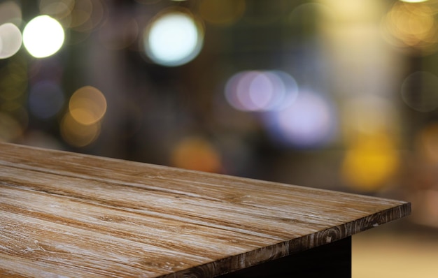 Foto a mesa de madeira vazia na frente do fundo desfocado abstrato da cafeteria pode ser usada para exibição ou montagem de seus produtos mock up para exibição do produto