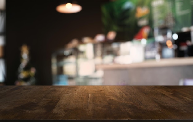 A mesa vazia de madeira escura na frente do fundo bokeh desfocado abstrato do restaurante pode ser usada para exibir ou montar seus produtos Mock up para espaço