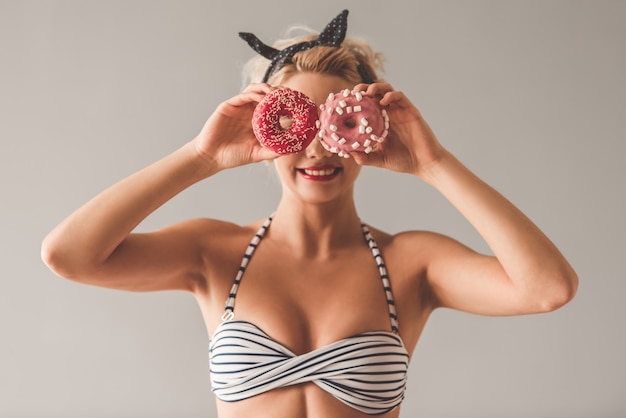 A moça à moda na roupa do verão está guardando anéis de espuma.