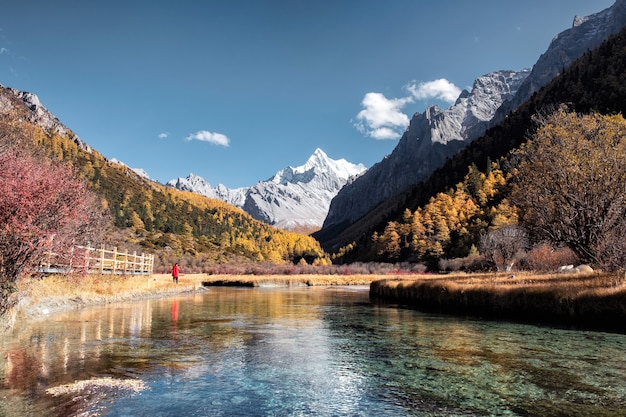 A montanha sagrada com lago esmeralda na floresta de outono na reserva natural de Yading, China