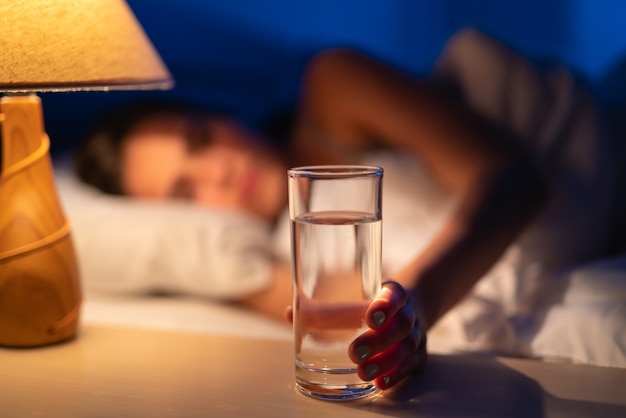 A mulher adormecida segurando uma dose de álcool