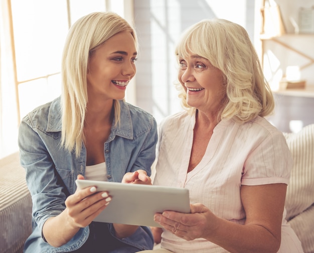 A mulher adulta e a rapariga estão usando uma tabuleta digital.