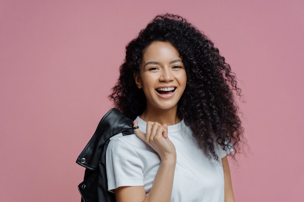 A mulher afro-americana positiva sorri toothy