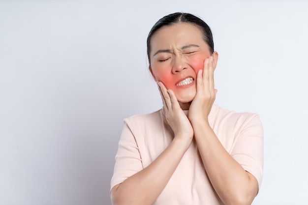 A mulher asiática estava doente com dor de dente isolada no fundo branco