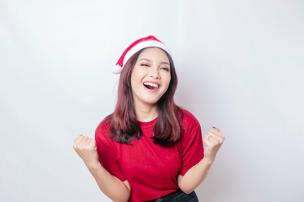 A mulher asiática feliz do Papai Noel está sorrindo isolada pelo conceito de Natal de fundo branco