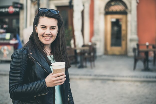 A mulher bebe o café fora