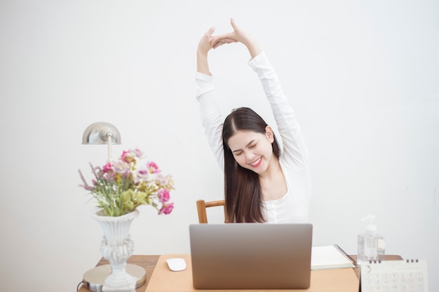 A mulher bonita está trabalhando em casa